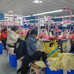 Skilled workers performing precise sweater panel connecting and tailoring at the factory assembly line