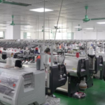 Massive automated computerized knitting machines workshop in sweater factory with rows of equipment