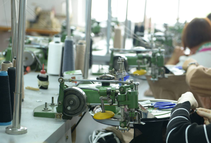 Garment linking machine joining sweater panels in knitting factory workshop